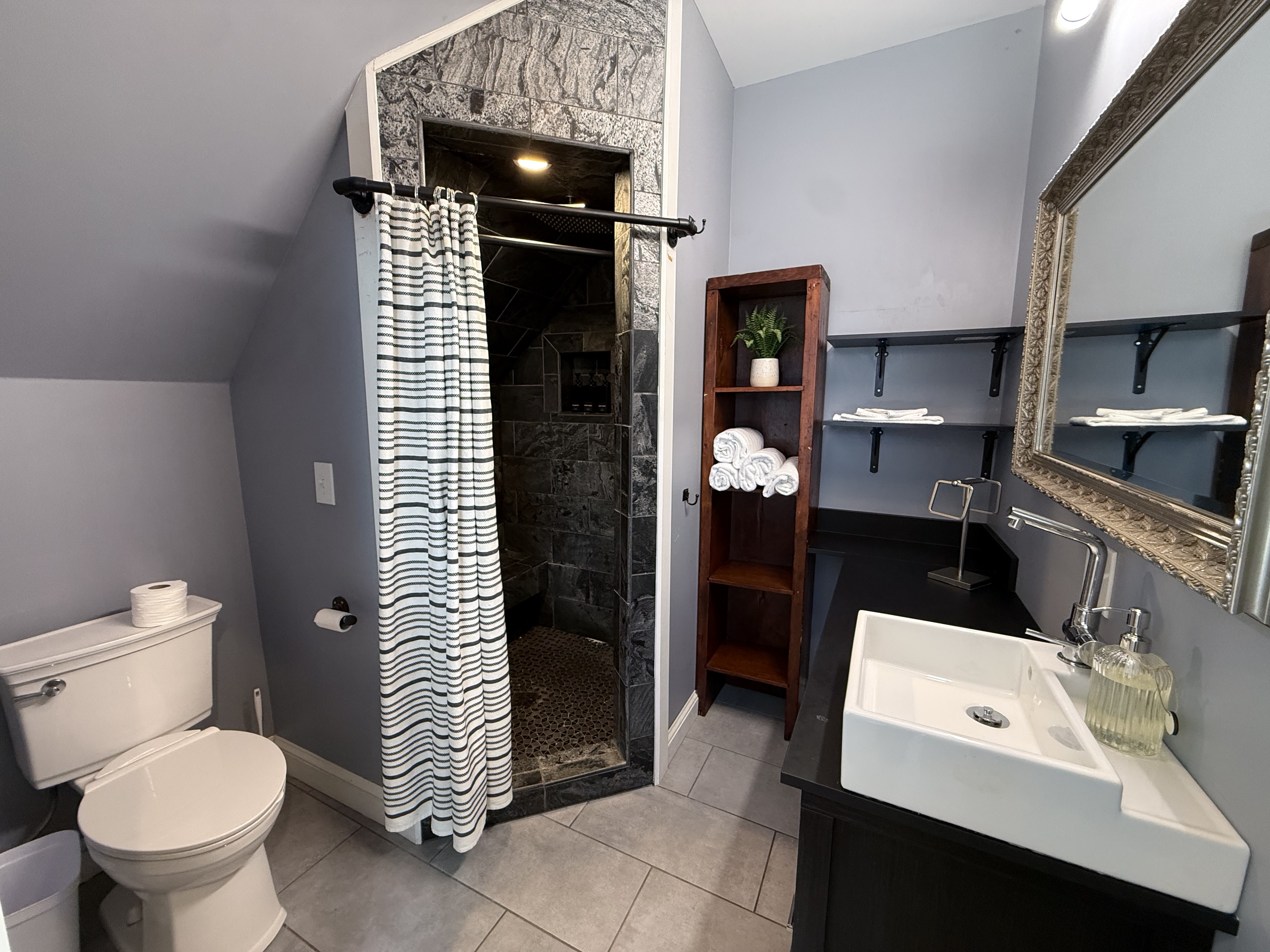 The Fifth — master en-suite bath with dark stone walk-in shower