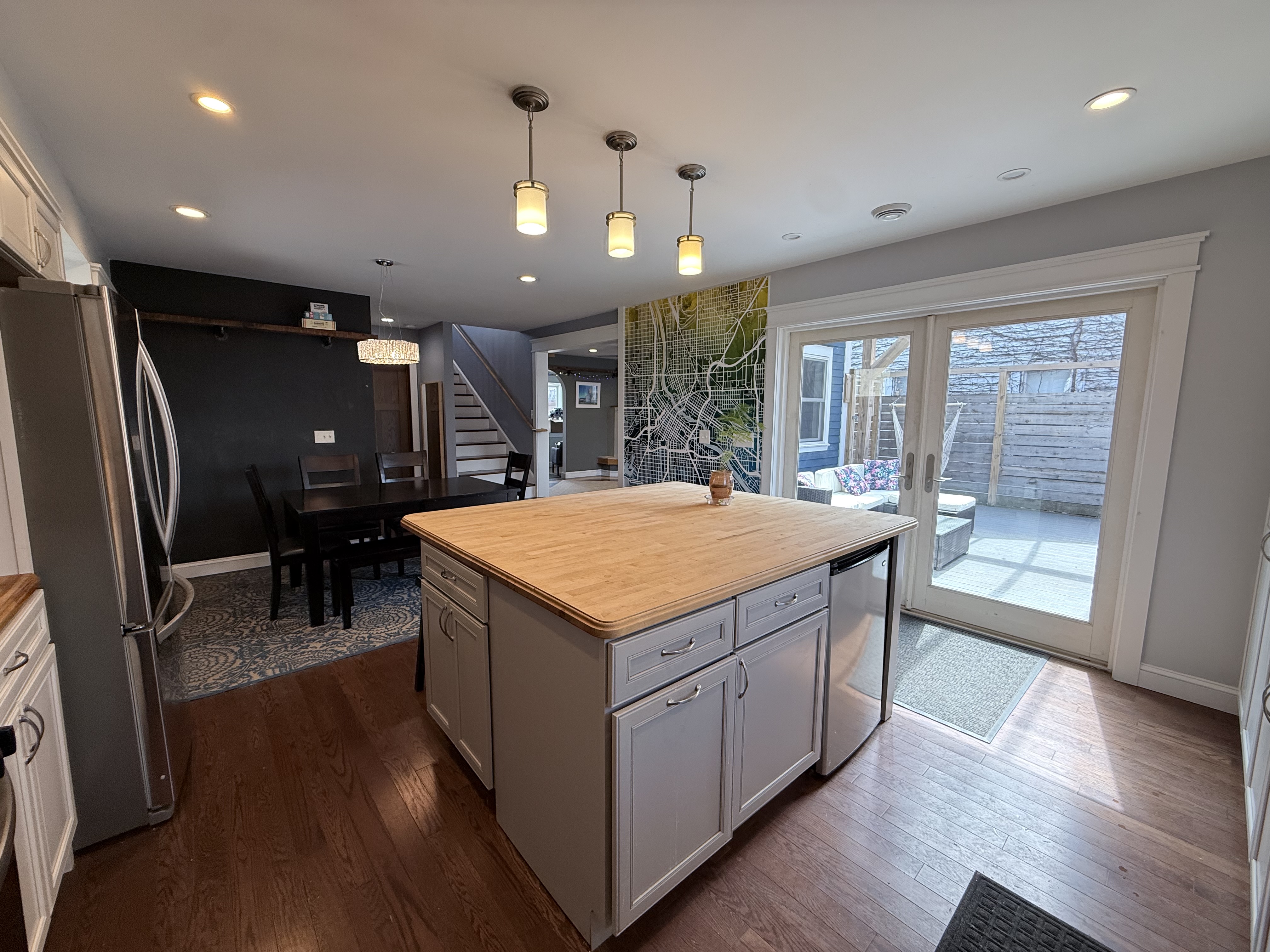 The Fifth — kitchen island with French doors open to the private deck