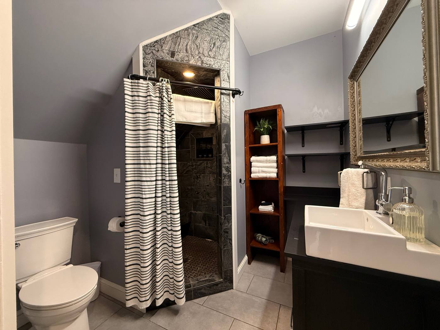 En-suite bathroom walk-in shower with dark stone tile