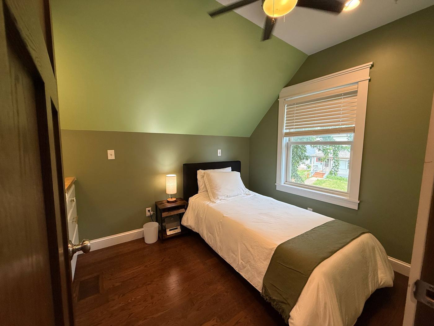 Upstairs bedroom with green vaulted ceiling and skylight