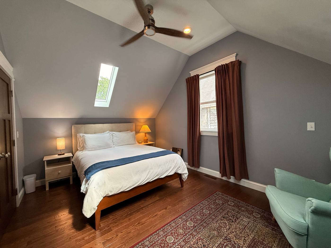 Master bedroom from doorway showing bed, rug and skylights